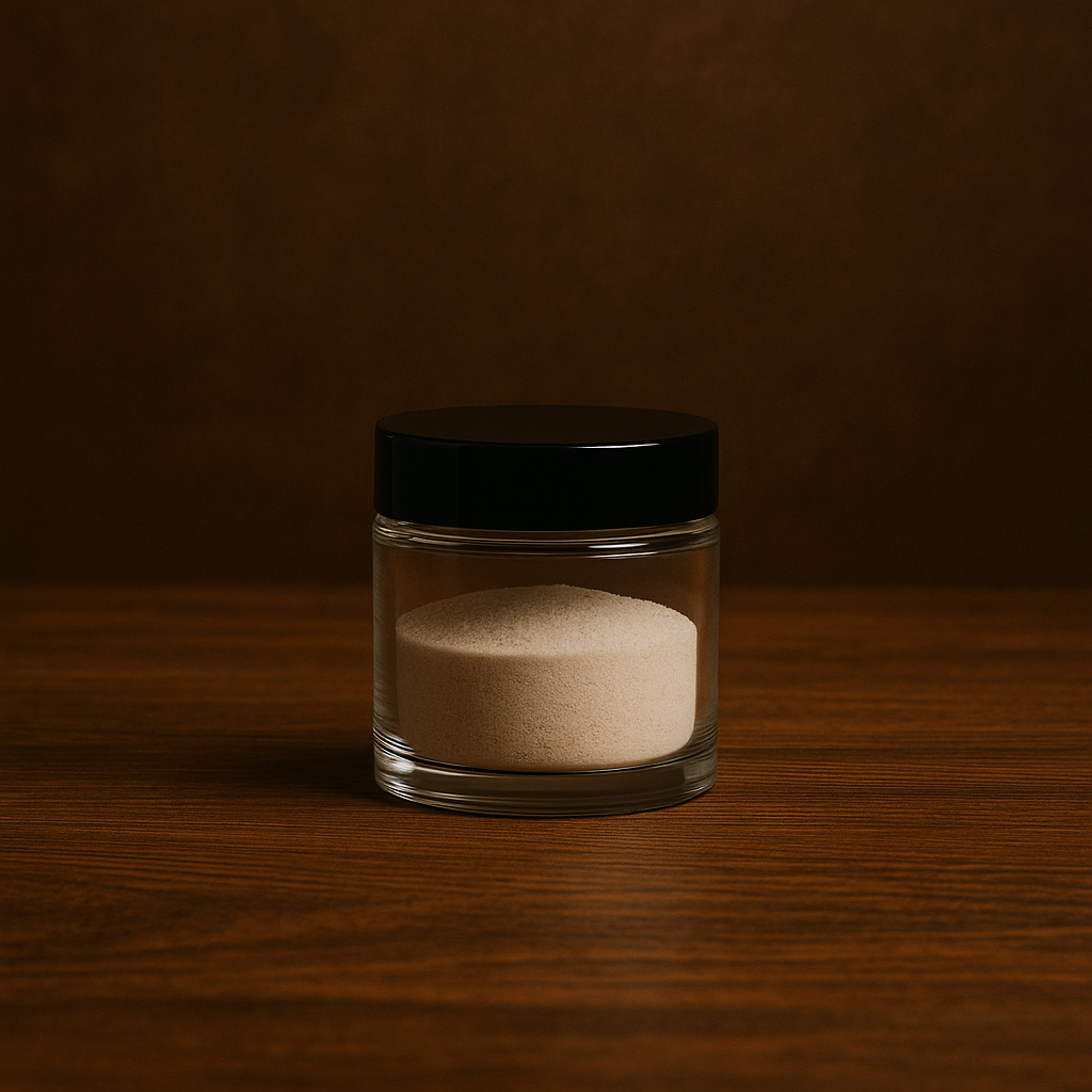 Glass jar with a black lid containing powder on a wooden surface with a dark background