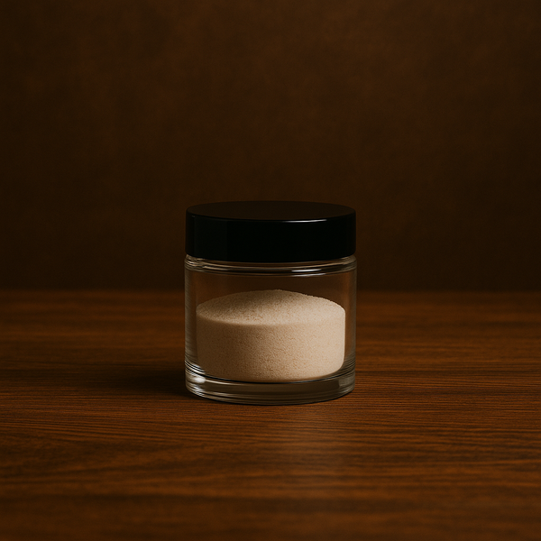 Glass jar with a black lid containing powder on a wooden surface with a dark background