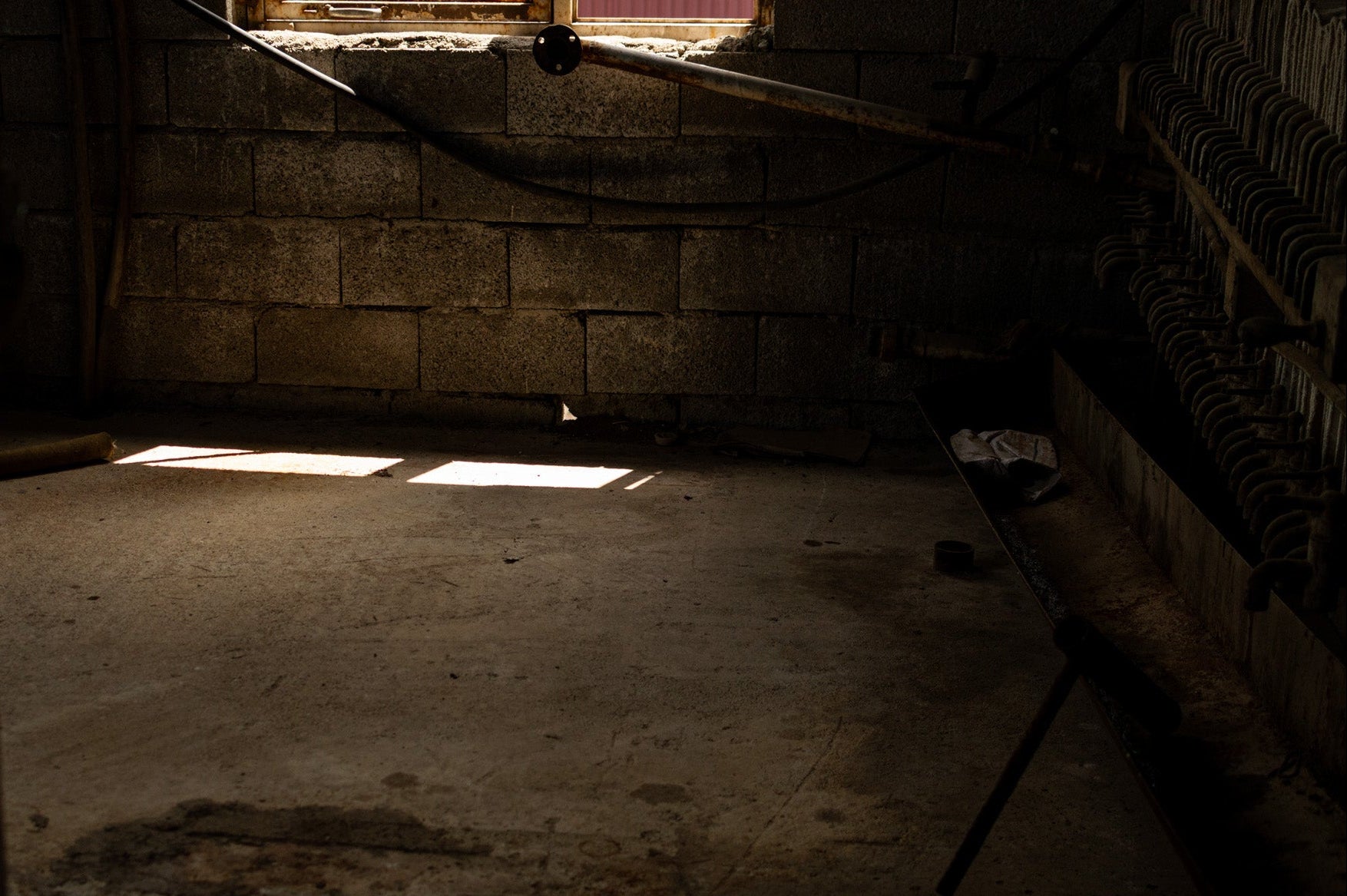 Dark, dimly lit room with stone walls and floor.