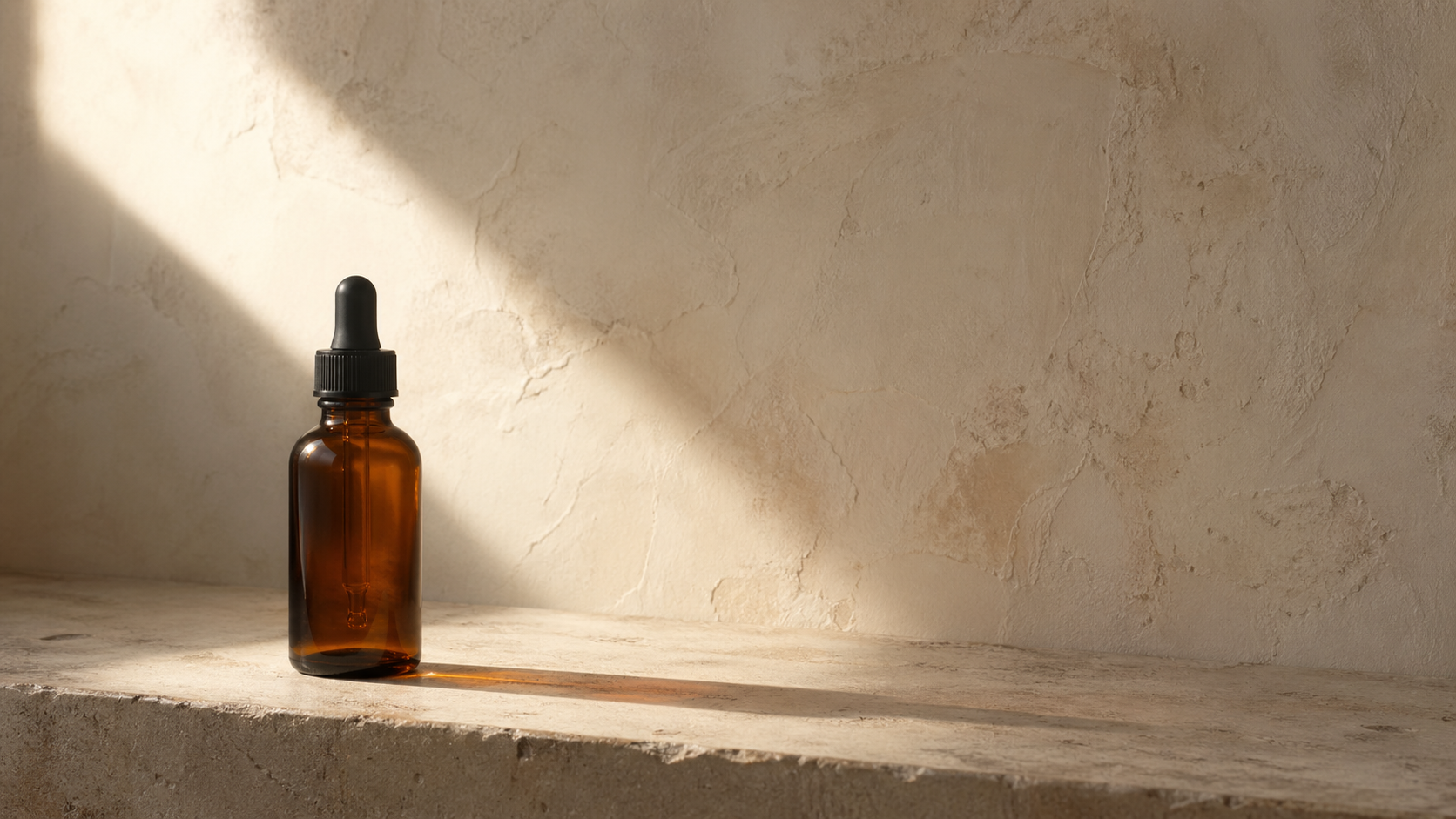 Amber glass dropper bottle on a textured stone surface with soft lighting